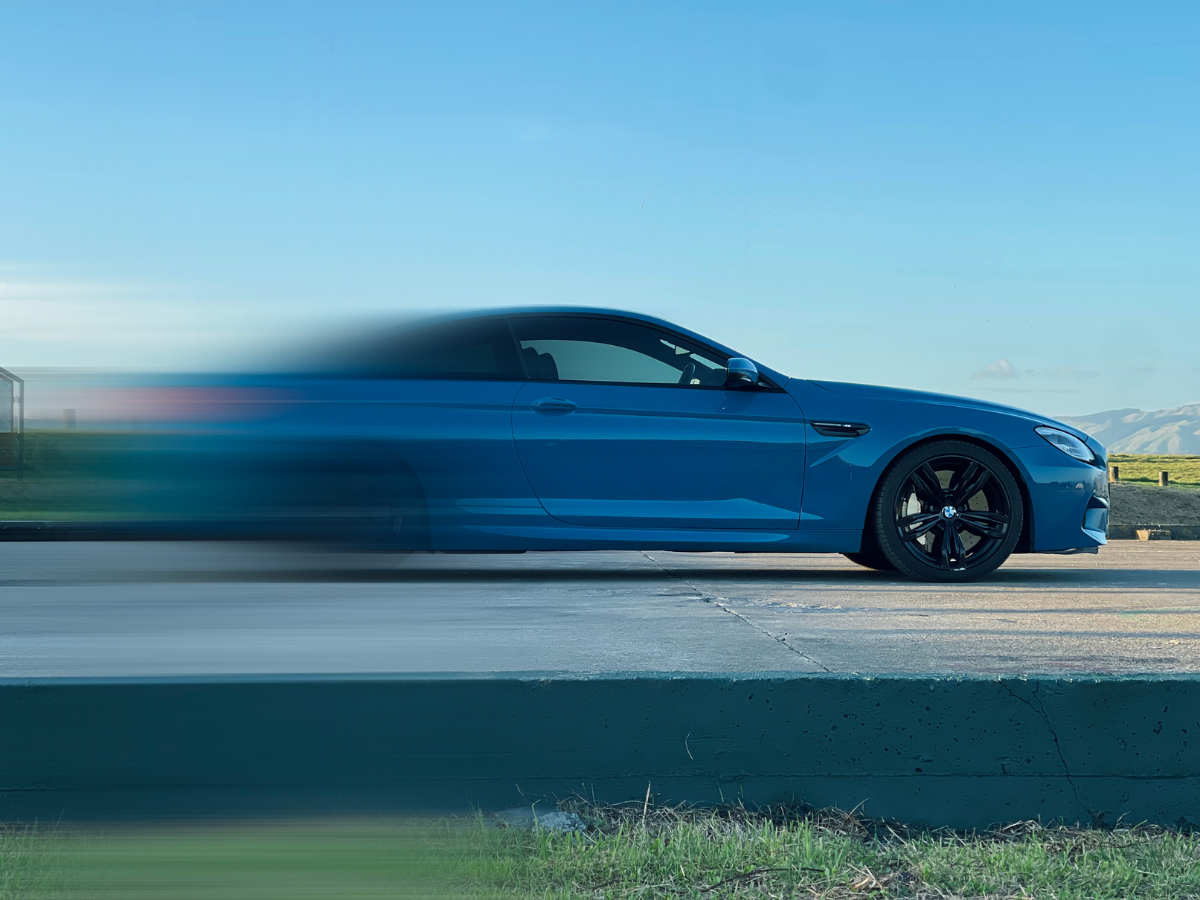 Photographer shooting a TAG The Agency liveried BMW M6 in a wet warehouse at golden hour