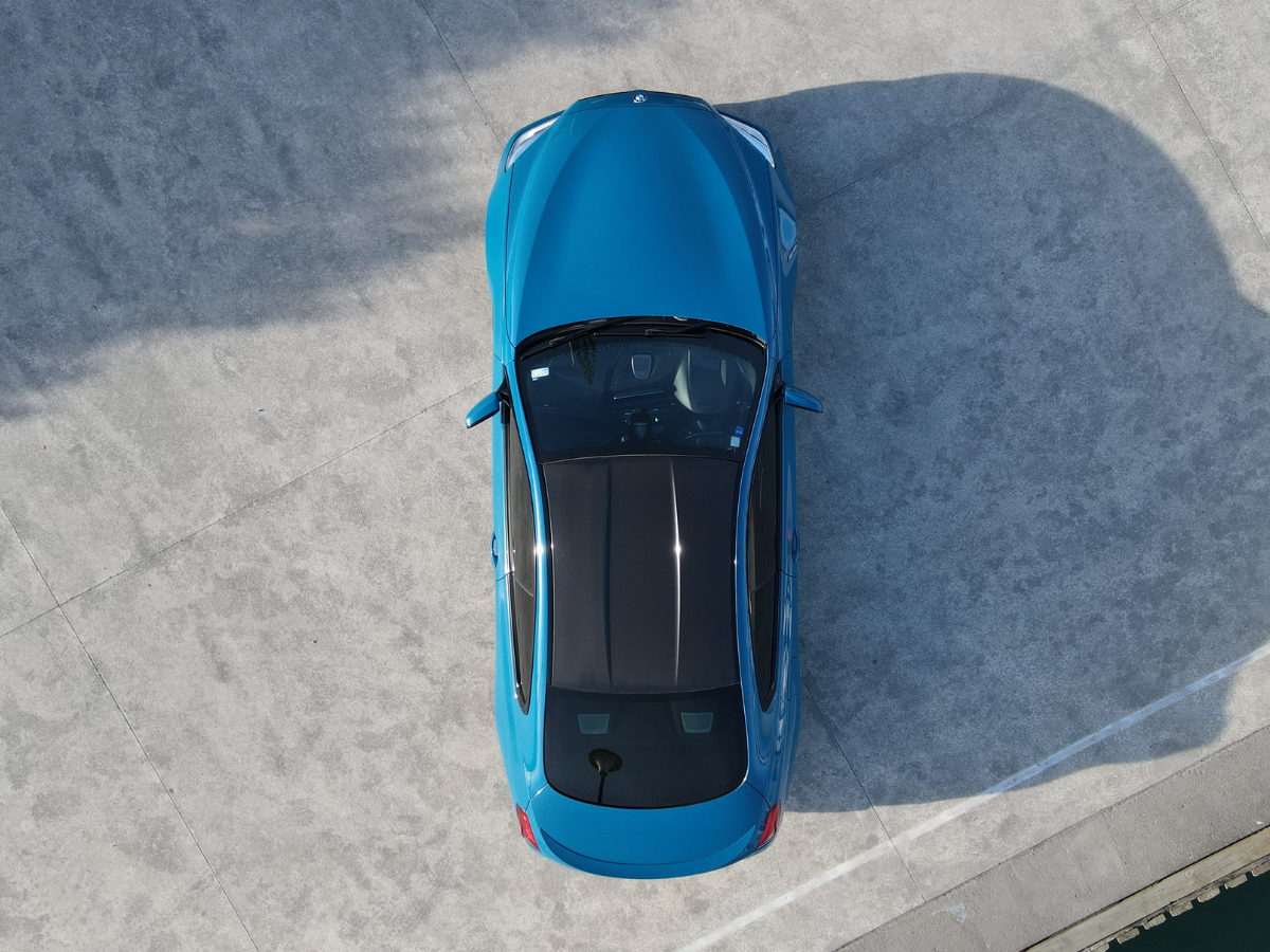 Overhead shot of a blue BMW on concrete